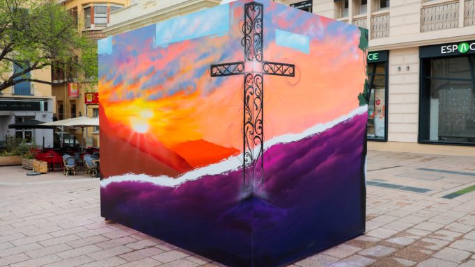 L'Art prend l'Air Perpignan 2026 Une fresque colorée représentant une croix sur fond de coucher de soleil.